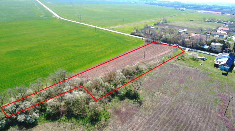 A plot of land in the area of Záhrady Ondrejovce, surrounded by fields and houses, bordered by a red line.