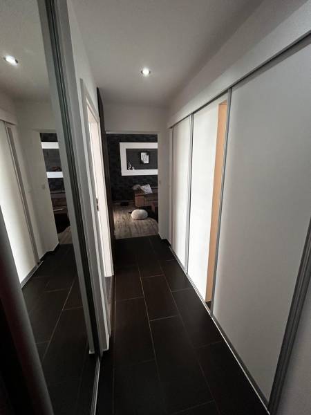 A hallway in a 3-room apartment with a dark floor and built-in wardrobes.