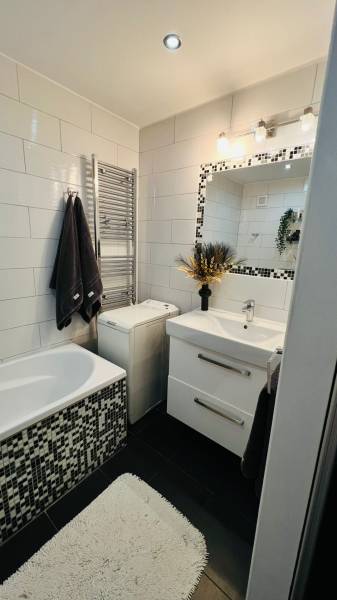 Elegant bathroom with tiles, sink, and bathtub, part of a 3-room apartment.