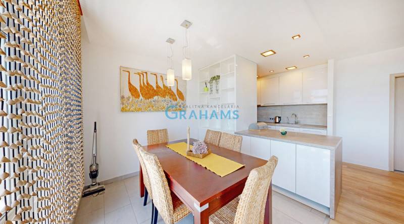 Dining area with a wooden table and decorative art in a 2-room apartment.
