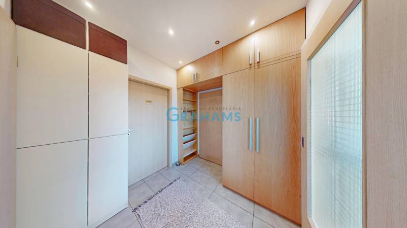 Built-in wardrobes and tiled floor in a 2-room apartment with light furniture.