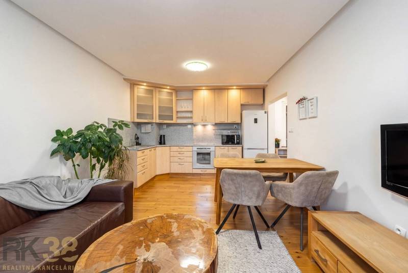 Living room with a kitchenette in a holiday apartment and a floor with a wooden decor.