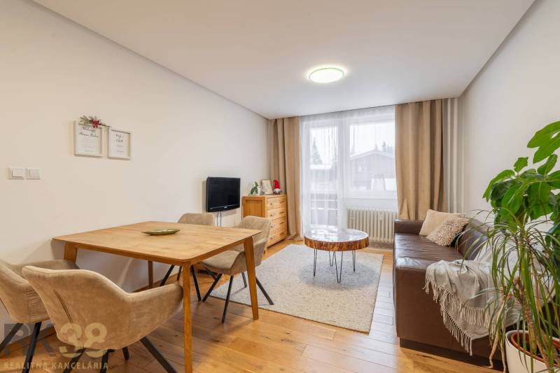 Living room in a holiday apartment with a cozy sofa and a wooden decor floor.
