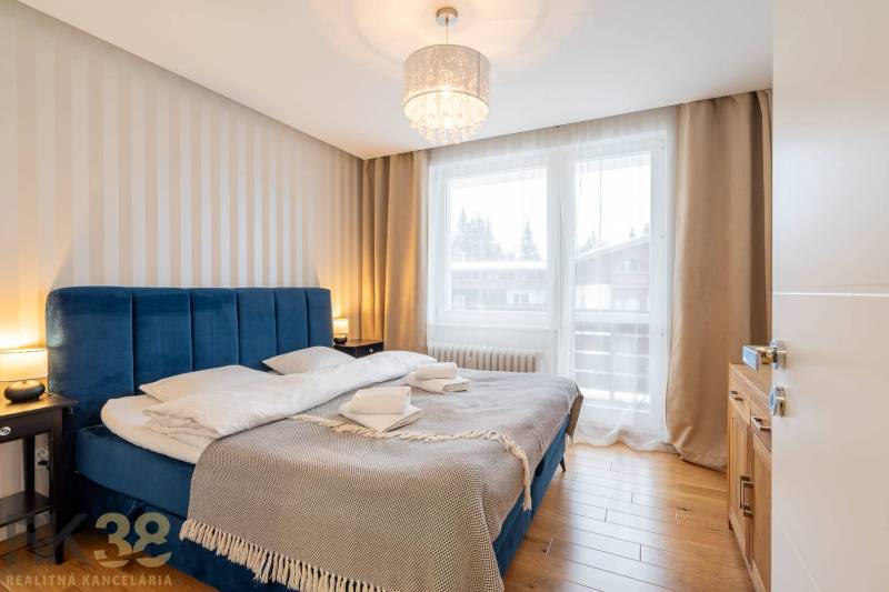 Bedroom in a holiday apartment with a comfortable bed and a wooden decor floor.