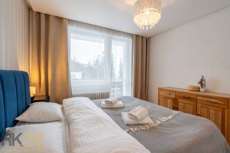 Bedroom in a holiday apartment with a double bed and a dresser, window with a view.