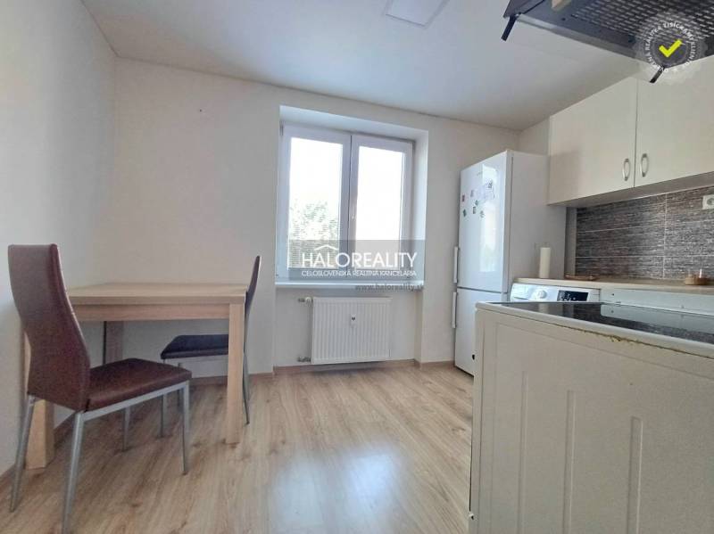 A kitchen in a studio apartment with furnishings and flooring featuring a wood decor.