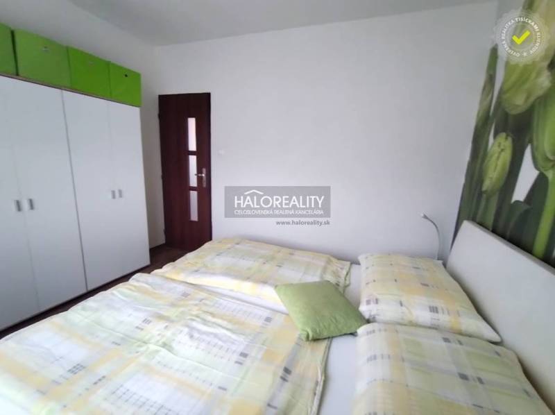 A bedroom in a 4-room apartment with a bed, a wardrobe, and a decorative wall with a flower.