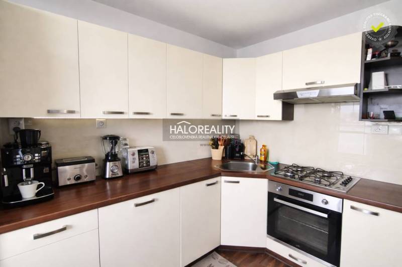 A kitchen in a 4-room apartment with white cabinets and a wood-patterned floor.