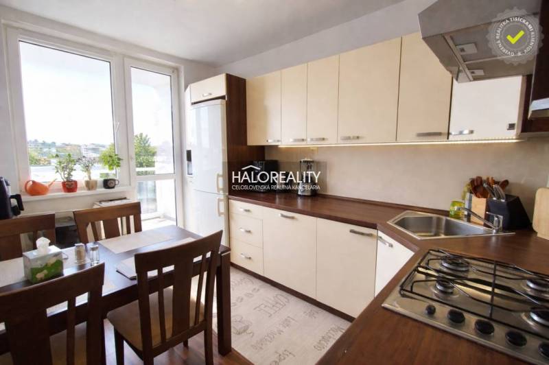 A kitchen in a 4-room apartment with a large window, a dining table, and light furniture.