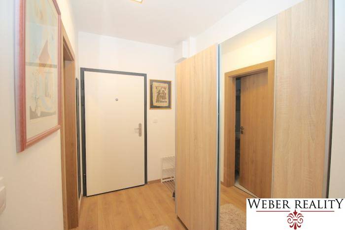 The interior of the hallway with a wood-patterned floor in a studio apartment.