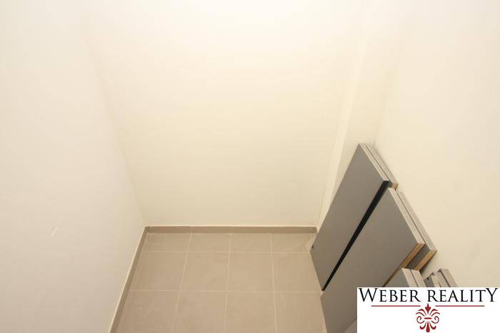 A small storage space in a studio apartment with tiled floors and white walls.