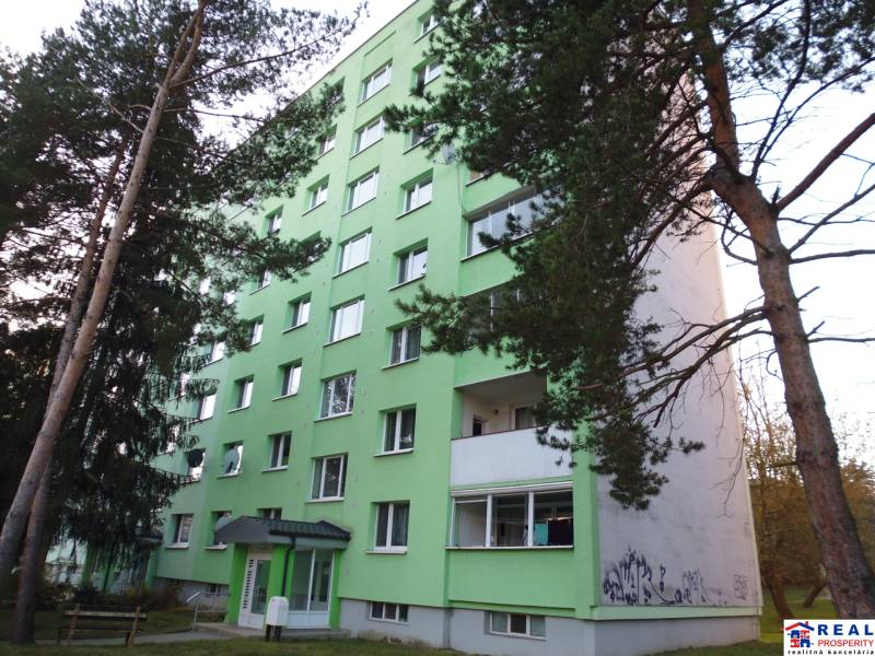 An apartment building in Prešov with surrounding trees and 7 floors.