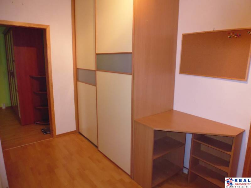 A workspace with furniture and flooring featuring a wooden decor in a 2-room apartment.