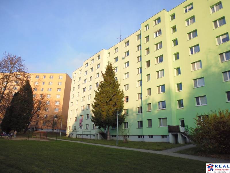 A housing estate with apartment buildings in Prešov, surrounded by greenery and a park.