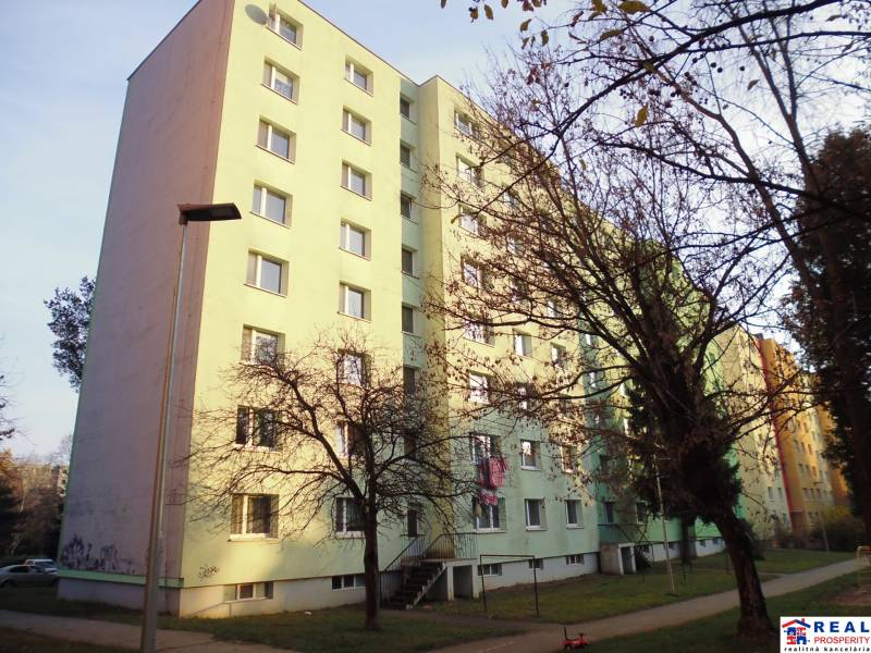 Apartment building in Prešov with a sidewalk and trees.