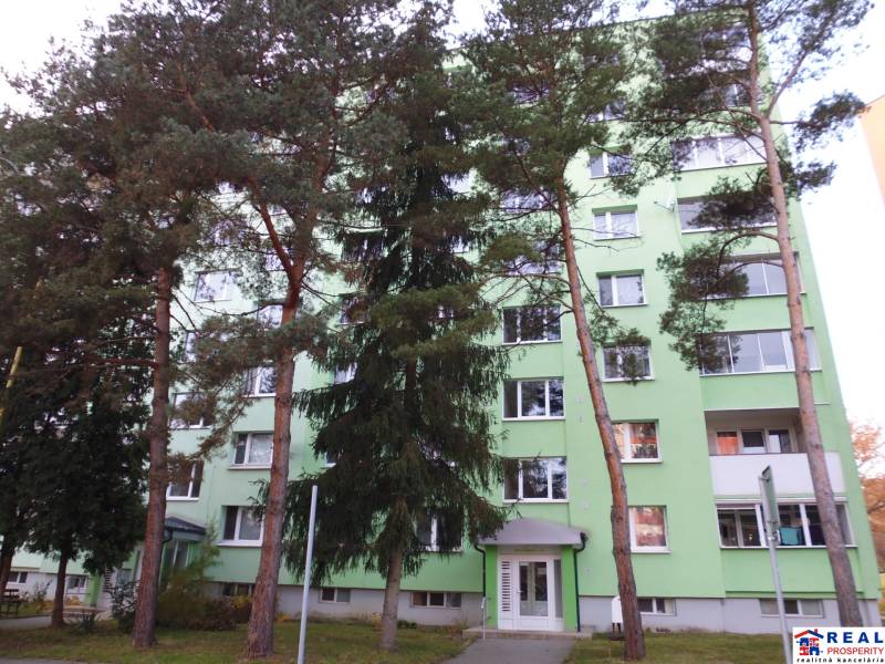 A green facade apartment building surrounded by trees in the city of Prešov offers a 2-room apartment.