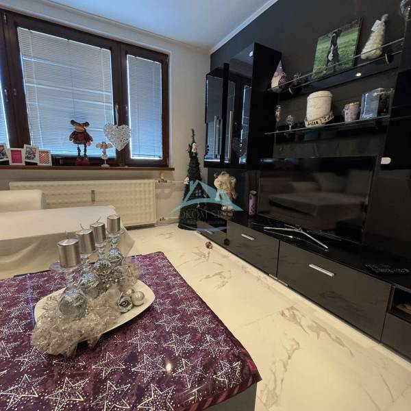 Living room in a two-room apartment with a marble floor and festive decoration.