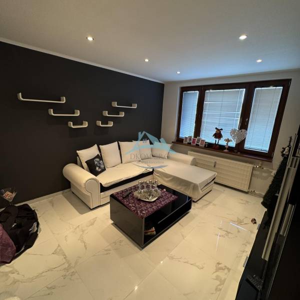 Living room in a two-room apartment with a dark wall and modern furnishings.