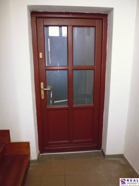 Wooden doors lead from the hallway of a 3-room apartment with a staircase.