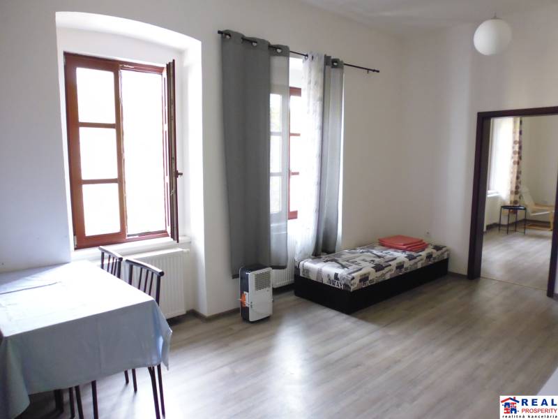 Living room with a table and sofa in a 3-room apartment, floor with wooden decor.