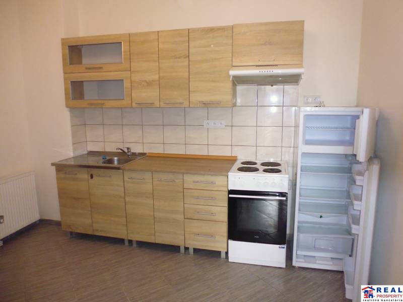 A kitchen unit with a wooden decor and appliances in a 3-room apartment.