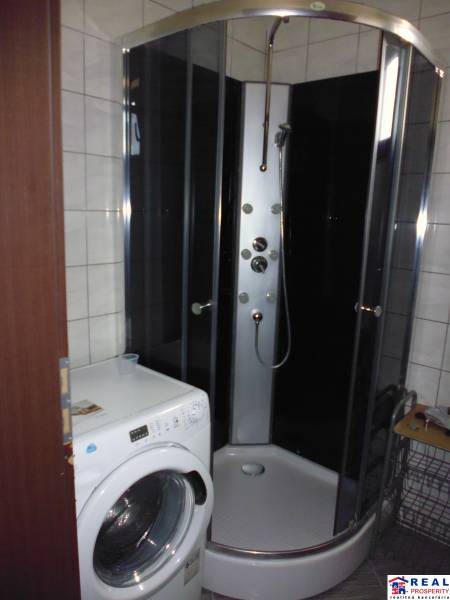 A bathroom in a 3-room apartment with a washing machine and a shower.