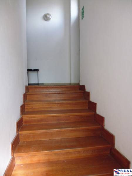 A staircase with a wooden decor floor leads to a wall in a 3-room apartment.