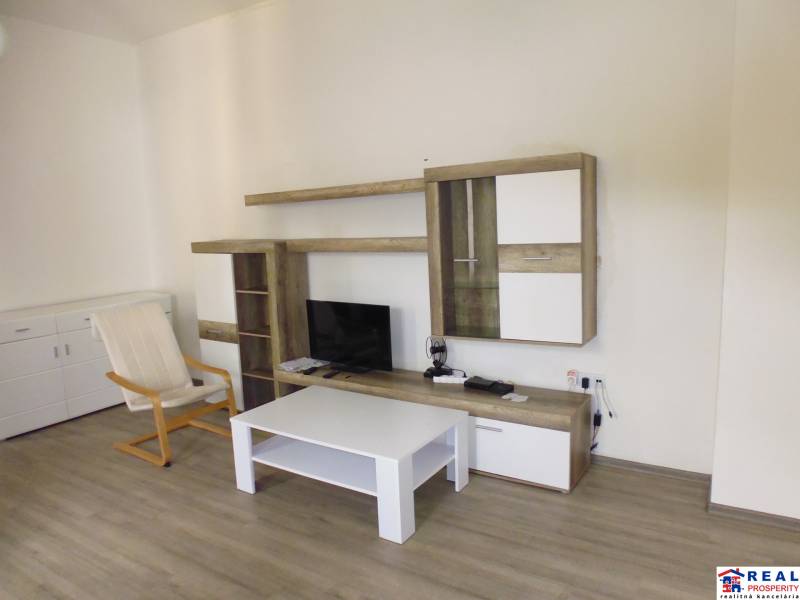 Living room in a 3-room apartment with a TV wall and wooden decor flooring.
