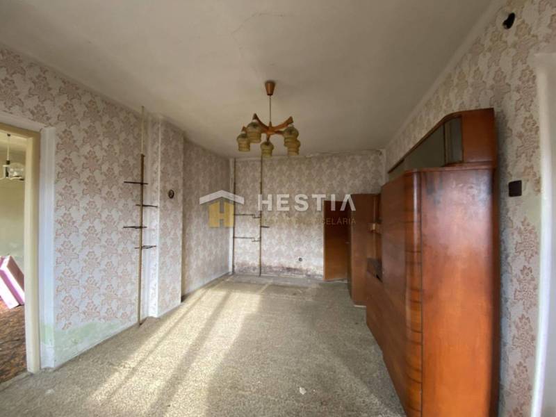 The interior of a family house with retro wallpapers and a wooden living room wall unit.