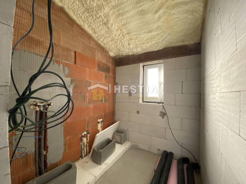The interior of an under-construction bathroom in a family house with preparations for installations.