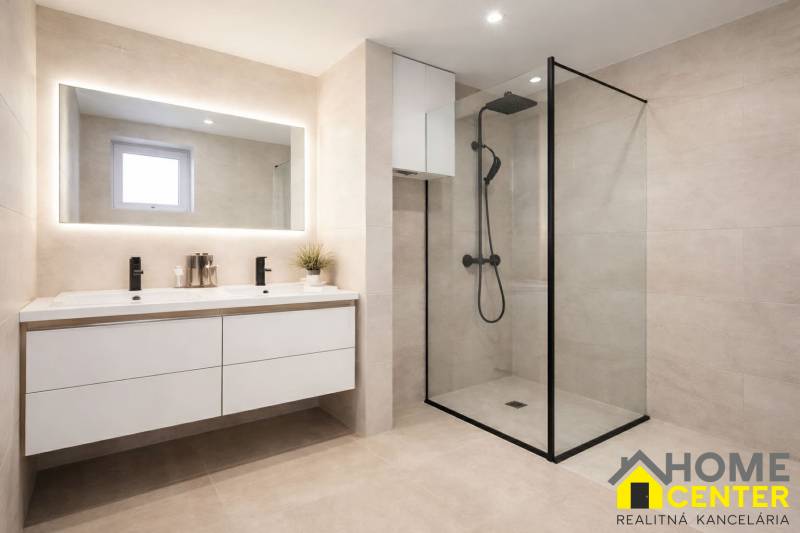 A bathroom with a large mirror and a shower in a family house.