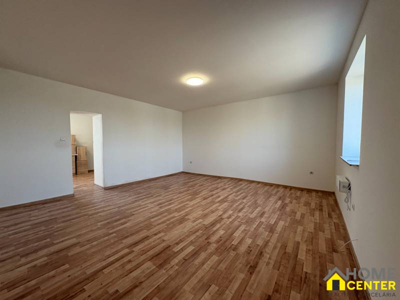 A room in a family house with a wooden decor floor and white walls.