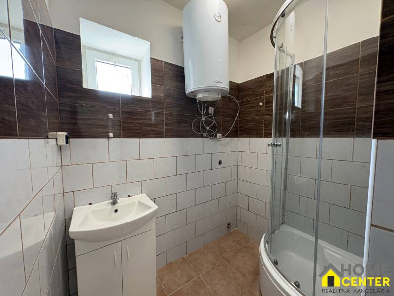 A bathroom in a family house with a modern shower and light tiles.