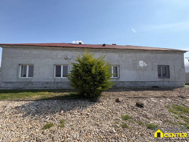 A family house in Zemianska Olča with a gray facade and a tiled roof.