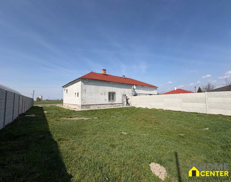 A family house in Zemianska Olča with a white facade and a red roof on a grassy plot.