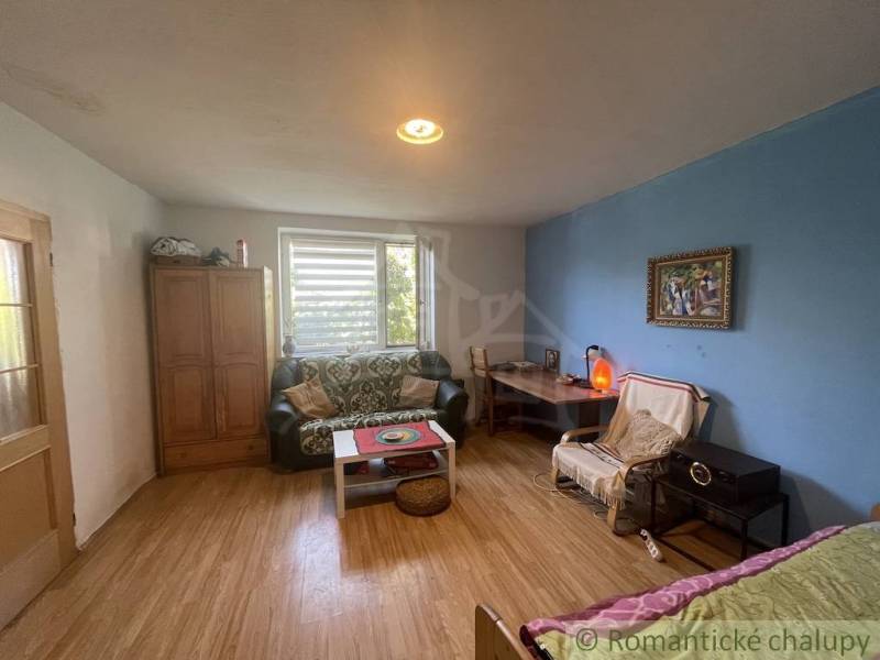 A room in a family house with a wooden decor floor, a couch, and a coffee table.