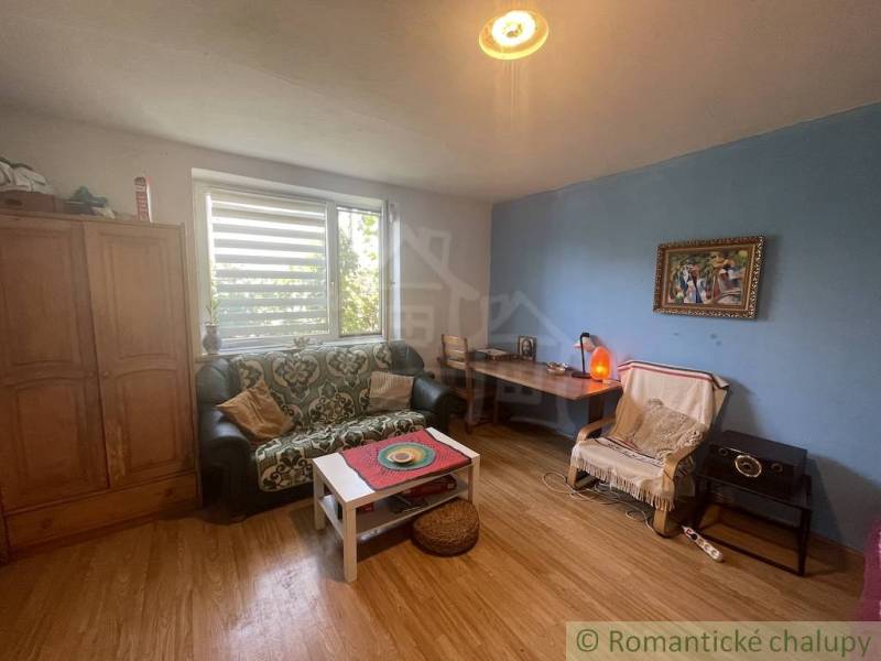 Living room with a sofa and wooden decor flooring in a family house.