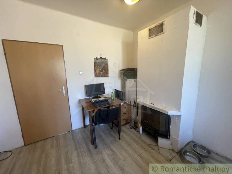 Interior of a family house with a fireplace, a desk, and a floor with a wood decor.