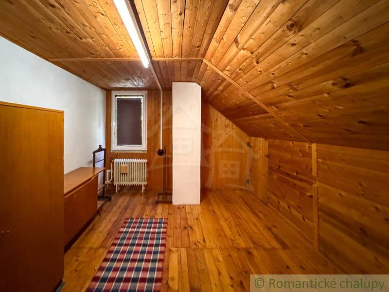 The interior of a cottage with a wooden decor floor and rustic furniture.