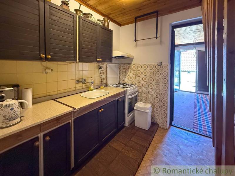A cottage with a rustic kitchen, wooden decor, and stylish cladding.