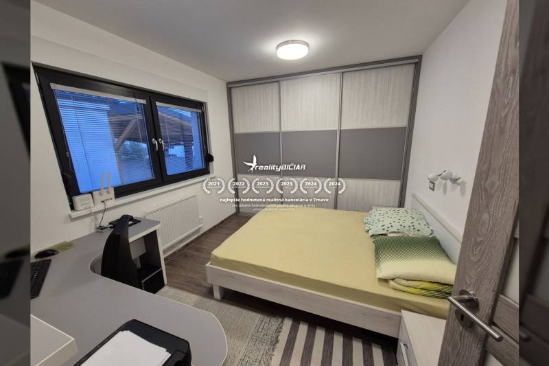 Bedroom in a family house with a bed, desk, and wardrobe.