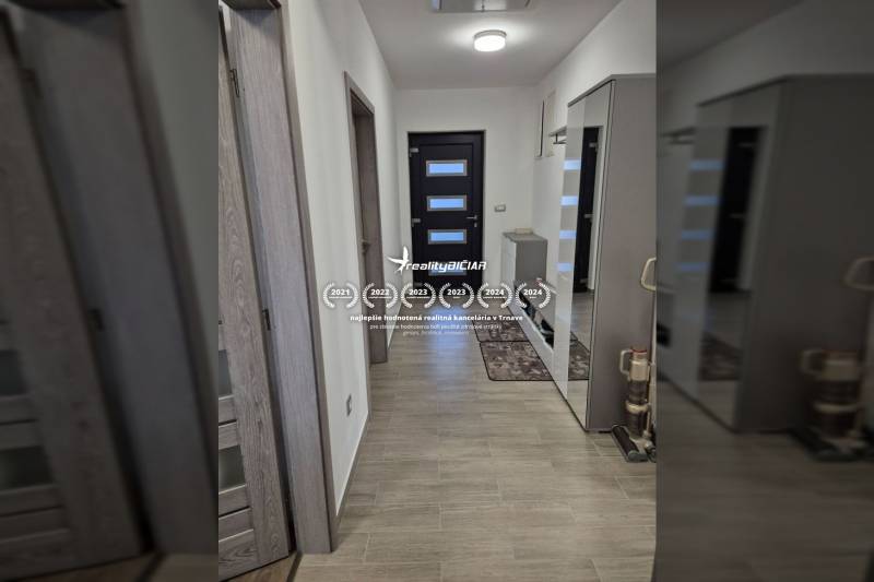 A hallway with a wooden decor floor in a family house with a mirror and a built-in wardrobe.