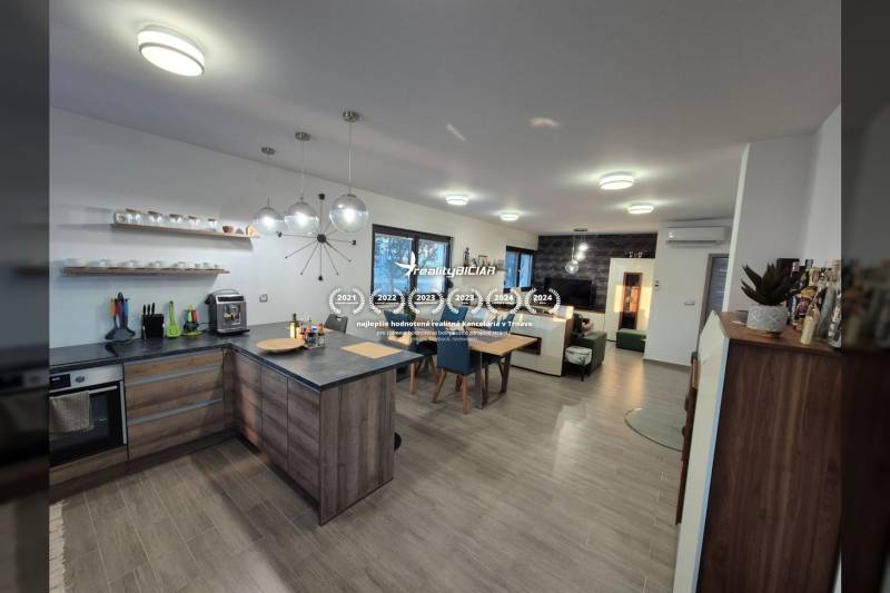 Kitchen and living room with wood-patterned flooring in a family house.
