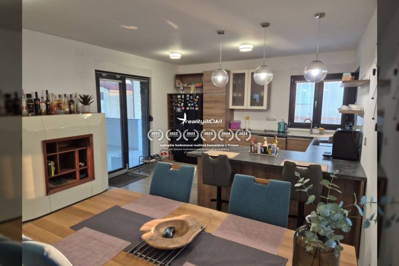 A kitchen in a family house with a dining table and a floor with a wooden decor.