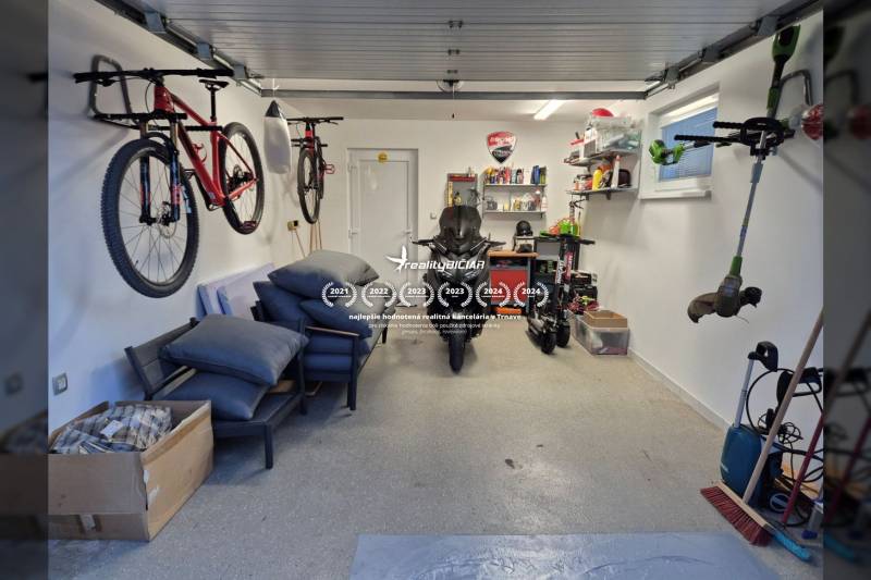 A family house garage with bicycles, a motorcycle, and shelves with tools and accessories.