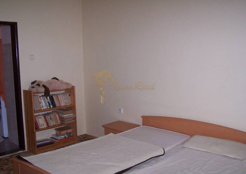 Bedroom with a bed and a bookshelf, ideal for a 2-room apartment.