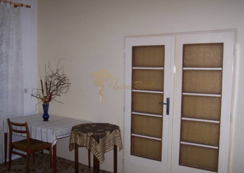 Interior of a 2-room apartment with a dining table and glass doors.
