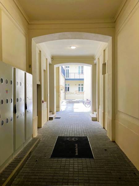 A hallway with checkered tiles, a bicycle in the background, a 2-room apartment on Konventna Street.
