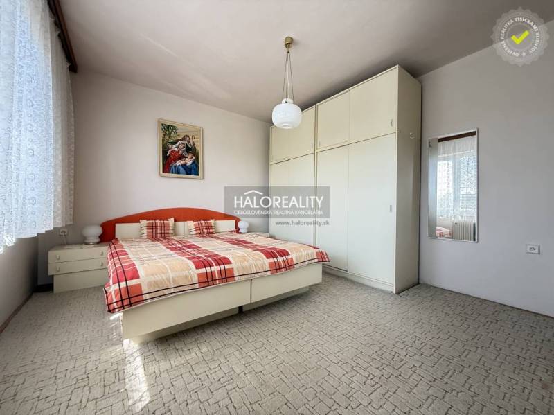 Bedroom in a family house with a large wardrobe, bed, and a picture on the wall.