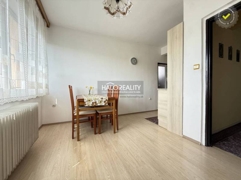 Dining room with wood-patterned flooring, table, and chairs in a family house.
